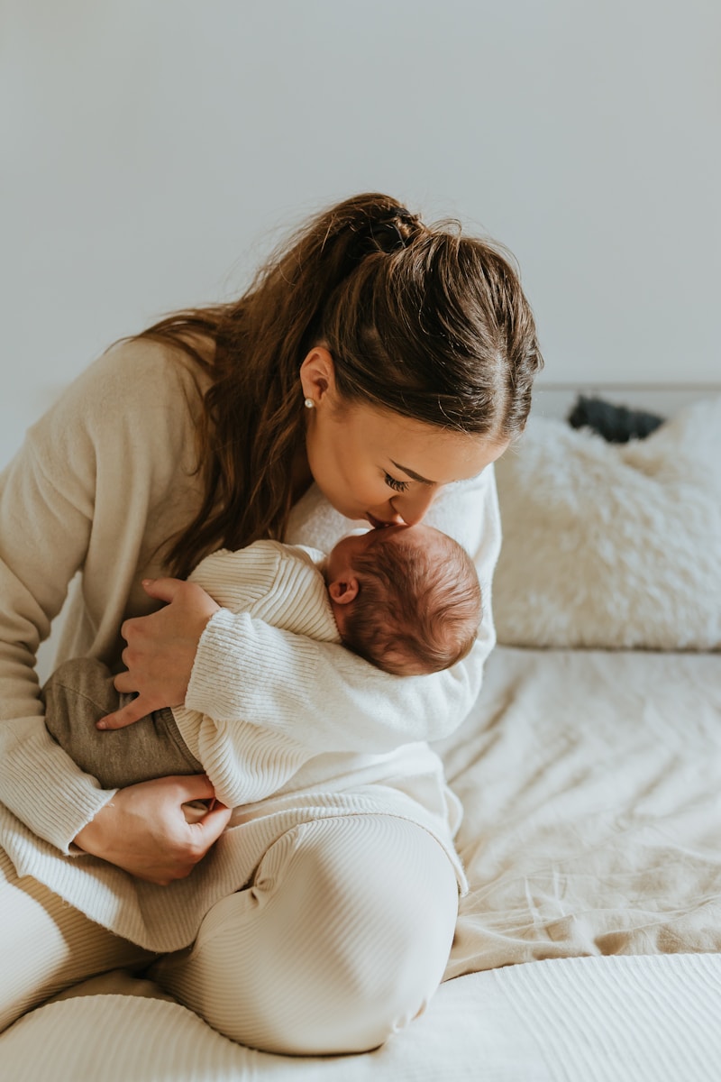 A woman holding a newborn baby in her arms — Thalam Studio maternity and newborn.